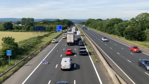 Traffic is building on a motorway where one lane is closed near an incident on the hard shoulder.
