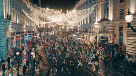 Entertainment A scene from Better Man shows hundreds of dancers performing on Regent Street in London