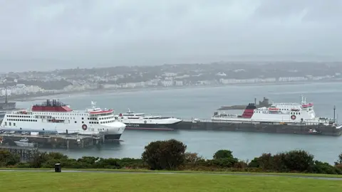 Three passenger ferries, painted in white, red and black, moored in Douglas Harbour.