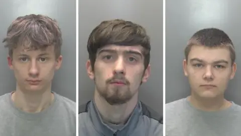 Cambridgeshire Police Custody images of Jordanas, a man wearing a grey T-shirt, Cole, a man in a grey zipped jacket and Thomas, a man with short brown hair, wearing a grey T-shirt. 