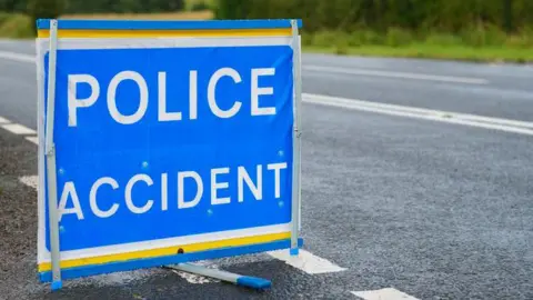 Getty Images A sign by the side of a road saying police accident. It is blue.