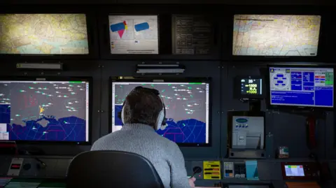 NATS An air traffic control officer looking at radar screens