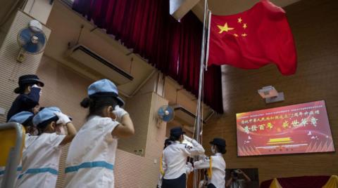 Students salute while watching the flag-raising ceremony to commemorate the 72nd anniversary of the establishment of the People's Republic of China