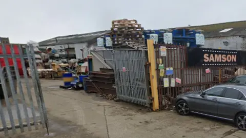 Google Streetview of premises with lots of objects and crates outside.