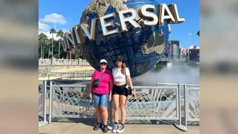 Family handout Maria Britton on the left with Emily on the right in front of the Universal sign at Universal in Florida