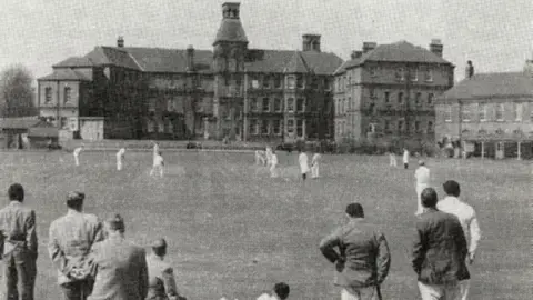 County Asylums Black and white image of cricket being played outside the hospital buildings