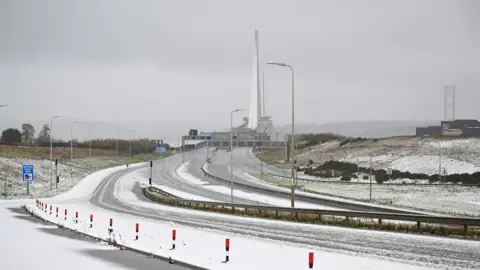 Reuters The pillars of the Queensferry Crossing successful  the region  with an bare  motorway covered with snowfall  successful  the foreground