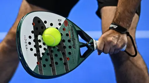 Close up of man hitting a tennis ball with a padel raquet