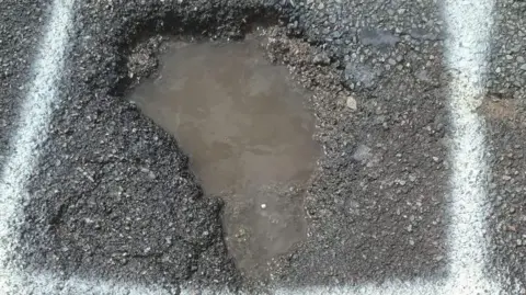 Supplied Pothole in road filled with water