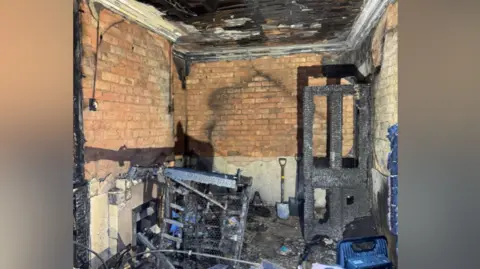 A room's interior shows fire damage, with charred walls and remnants of furniture. 