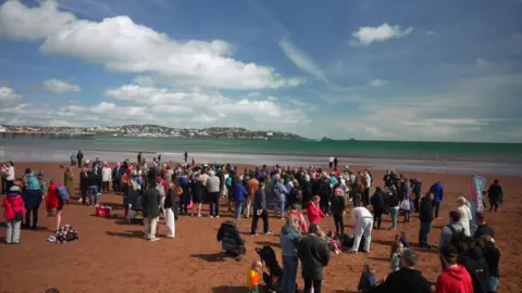 People gathered at Paignton beach to watch baptisms take place. 