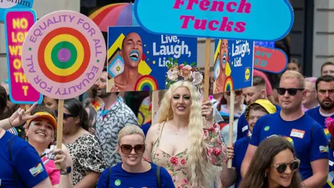 Getty Images Crowds holding varuois placards during Pride Cymru parade.