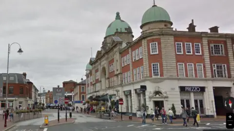 Google A street view image of Mount Pleasant Road in Tunbridge Wells in the day time, showing a Victorian neo-palladian building, traffic and the bus gates area near the town centre.