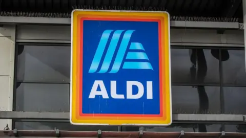 A yellow, orange and red border on a blue rectangular logo with the store name 'Aldi' in the centre