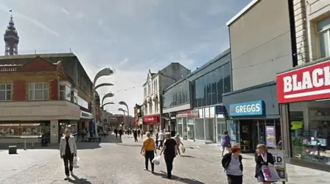 Shoppers on Church Street, Blackpool, on a sunny day with Blackpool Tower in the background. 
