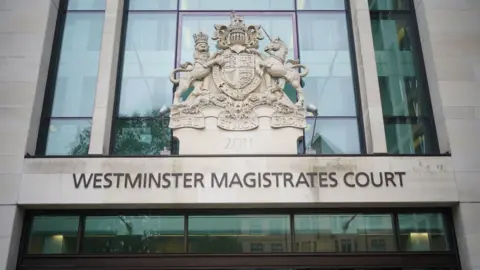 A general view of the entrance to Westminster Magistrates Court. The name of the court is written on the front of the building above an entrance. The HM Courts and Tribunal Service embled rests above the court name.