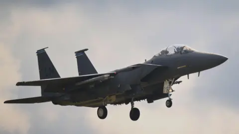 A F-15E plane flying in the sky.