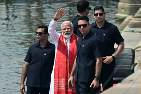 Getty Images Le Premier ministre indien Narendra Modi (au centre) salue après avoir offert des prières sur les rives du Gange à Varanasi le 14 mai 2024, lors des élections générales en cours dans le pays.