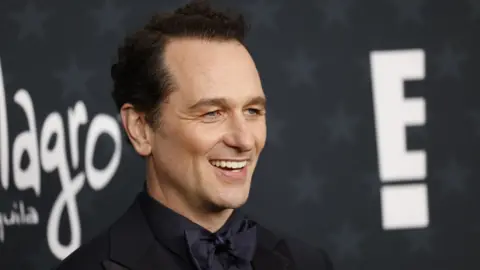 EPA Matthew Rhys smiling in a black bow tie at a premiere