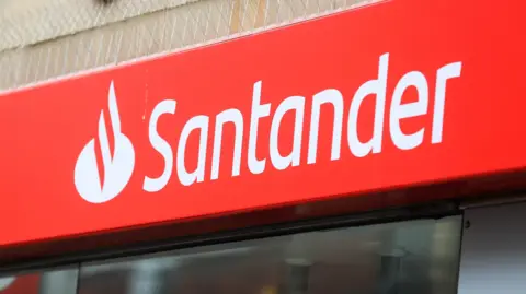 A close up of the red Santander sign above the entrance of a bank building.