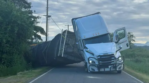 An overturned lorry in the middle of the road