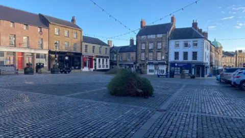 A Christmas tree on the ground in the market square in Alnwick 