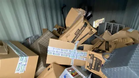 Richard Thomas Brown boxes all discarded and ripped open, messily chucked about the place. 