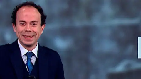 Man with blue tie, white shirt and black hair