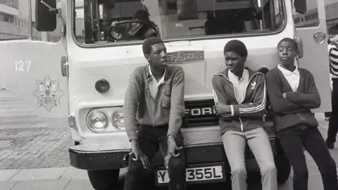 Three boys lean on a fire engine in Coventry city centre