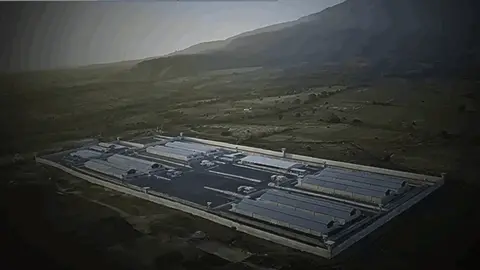 An aerial view reflects the gel complex surrounded by high walls and guards.