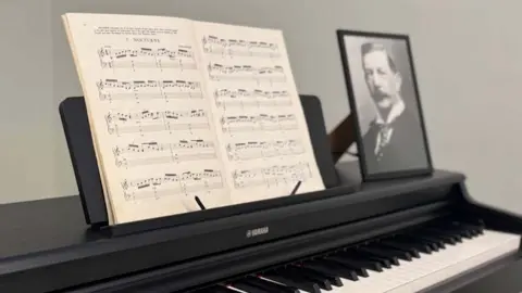 LCC Open sheet music with a black-and-white photo of Massey on a black piano.