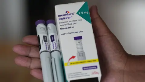 A pharmacist displays a box of Mounjaro, a tirzepatide injection drug used for treating type 2 diabetes made by Lilly.