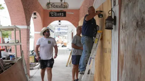 Getty Images People put up boards to prevent wind from damaging their windows