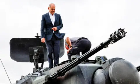 Reuters Chancellor Olaf Scholz standing on a Gepard self-propelled anti-aircraft gun