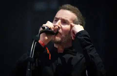 Robert Del Naja from Massive Attack sings on stage during their concert on The Downs in Bristol.