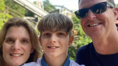 Ellen Roome Jooles in the middle and his mum and dad, left and right, smiling at the camera 