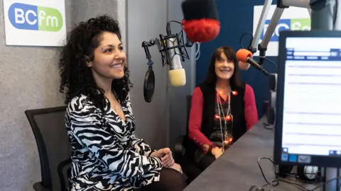 BCFM Two women sitting in front of microphones in a radio studio