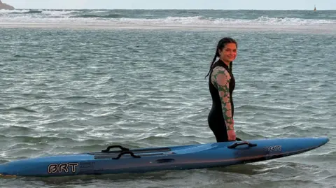 Young girl alongside rescue board in the sea 