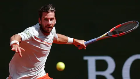 Cameron Norrie, in largely white T-shirt with orange trim, plays a forehand at the Monte Carlo Masters on Sunday