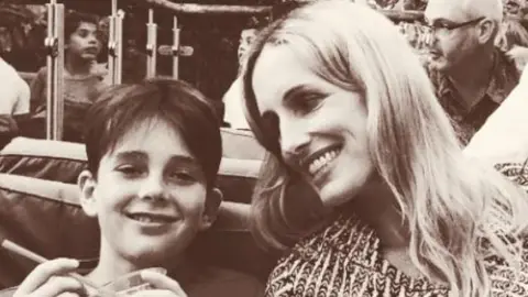 Sam Robinson A black and white photo of a woman smiling at her child.