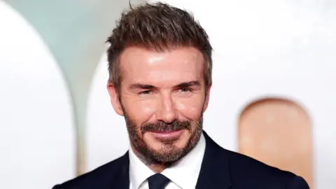David Beckham wears a black suit and tie at the premiere of the "99" documentary about Manchester United. 