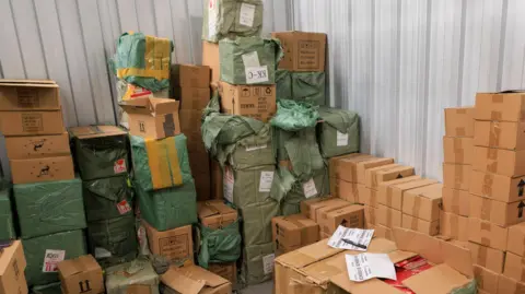 Greater Manchester Police Cardboard boxes of counterfeit goods stacked high in an industrial unit
