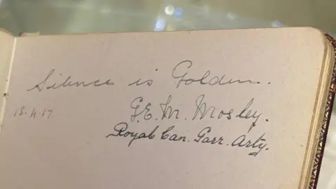 Kevin Shoesmith/BBC An entry in a notebook reads "Silence is golden." It is signed "G.E.M. Mosley."