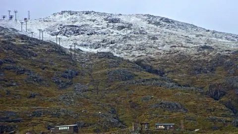 Winterhighland A layer of snow on the higher slopes with lifts and buildings at Glencoe Mountain Ski Resort