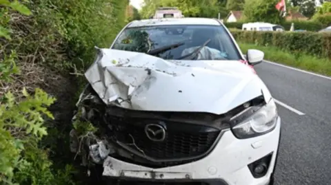 Sussex Police A white car with damage to the front sits facing the camera