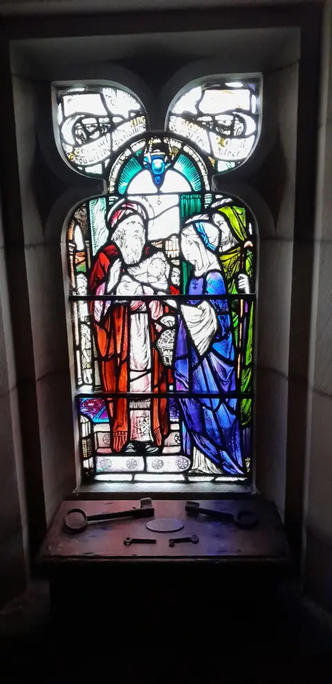 Linton Heritage Kirk Appeal Looking out through a stained glass window in Linton Kirk featuring a male figure in red robes and a female figure in blue robes.