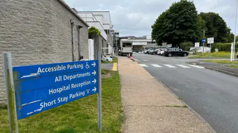 BBC Princess Elizabeth Hospital - A blue sign pointing to Guernsey's hospital main entrance. 