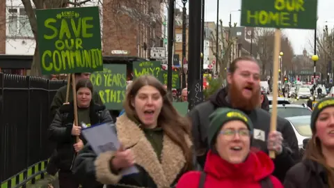 Club members, with signs that read 'save our community' and '100 years for this' march to Brick Lane on Sunday afternoon