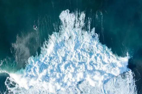 Getty Images An aerial view of white, frothing surf as waves crash into the north Caithness coast.