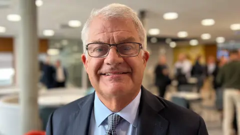 BBC Man in suit looks at camera